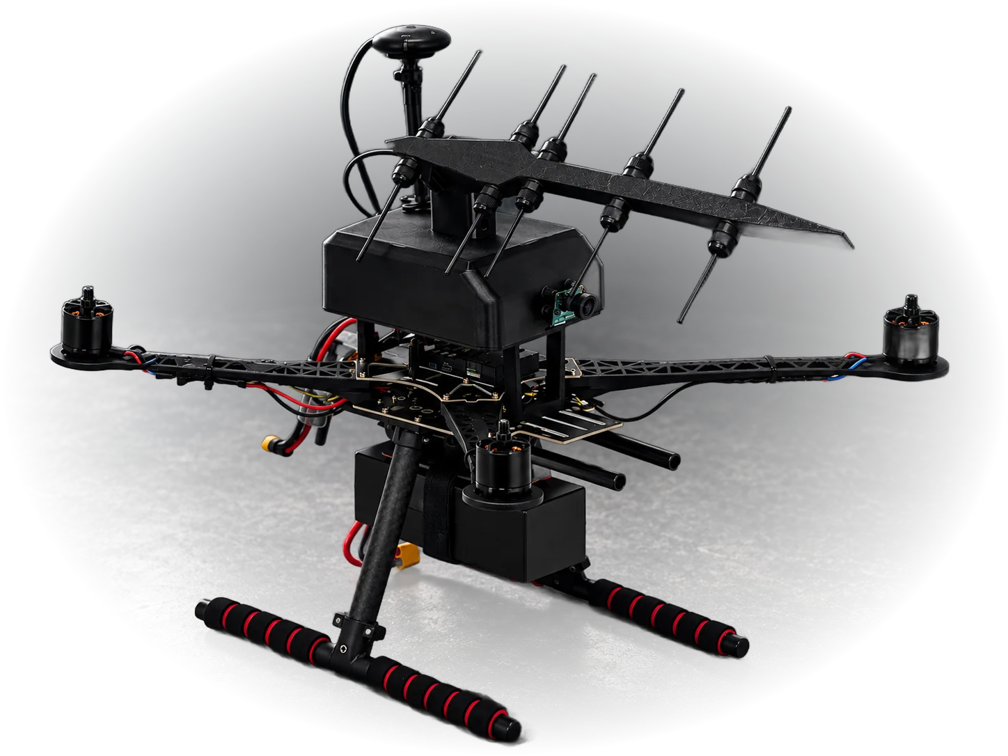 The Lykos payload mounted on a rugged quadcopter airframe: a Yagi-style directional antenna array above a hardened enclosure with an integrated camera, flanked by a GPS antenna and carbon-fiber landing legs.